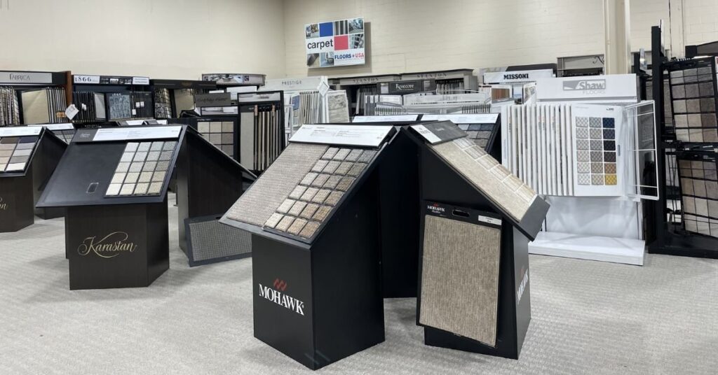 A spacious room displaying a variety of carpet samples in different colors and textures for selection.