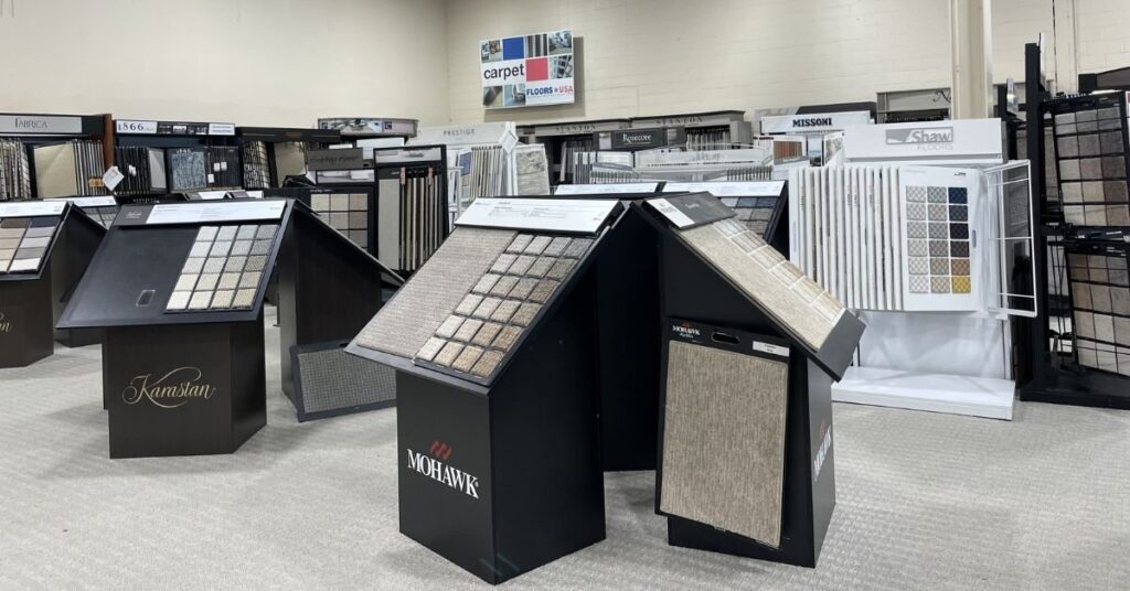 Floors USA display of various carpet samples arranged in a store, showcasing different colors and textures for customer selection.